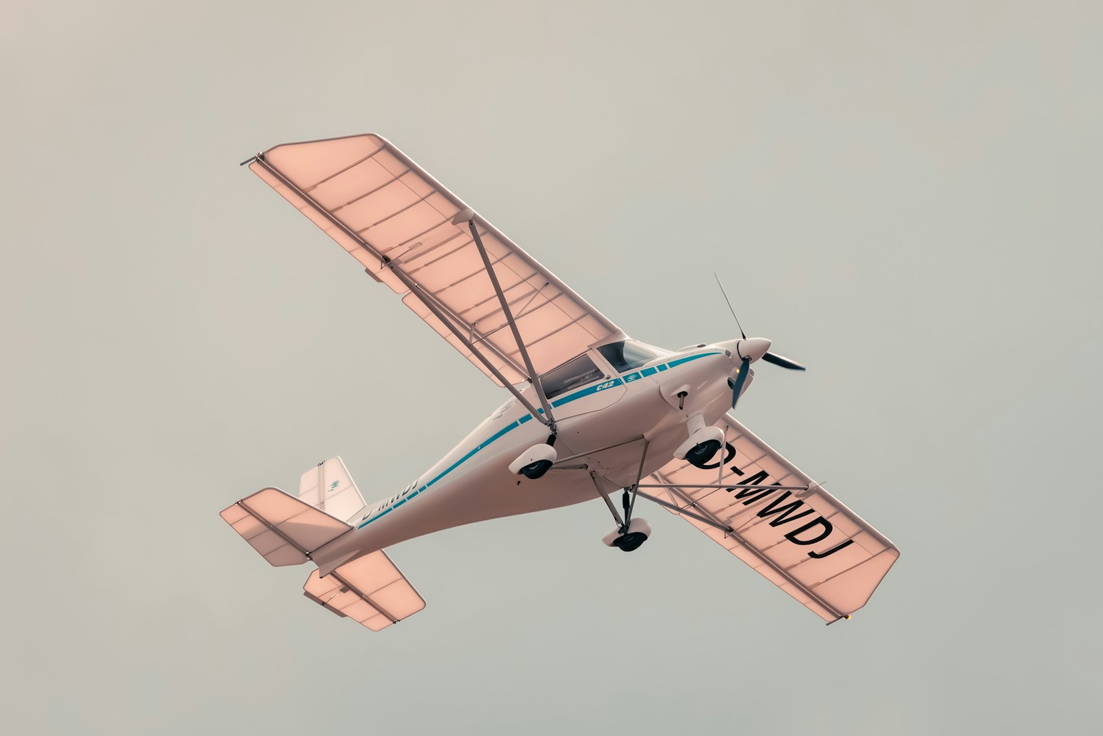 Photo by Matthias Wesselmann a small airplane flying through a gray sky
