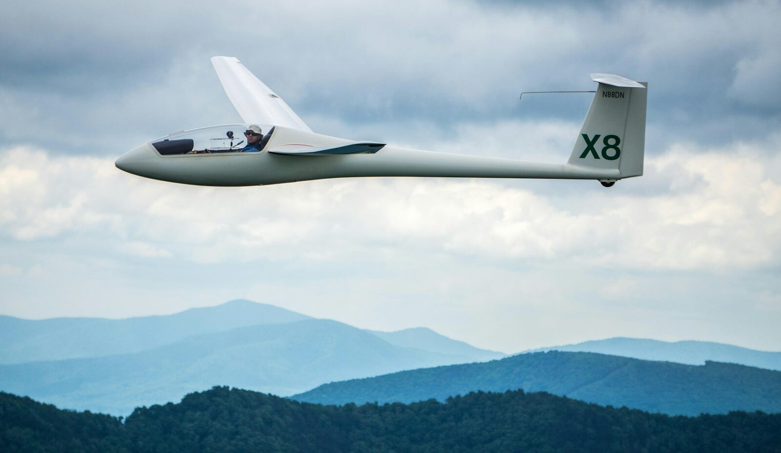 flying white X8 under cloudy skies during daytime