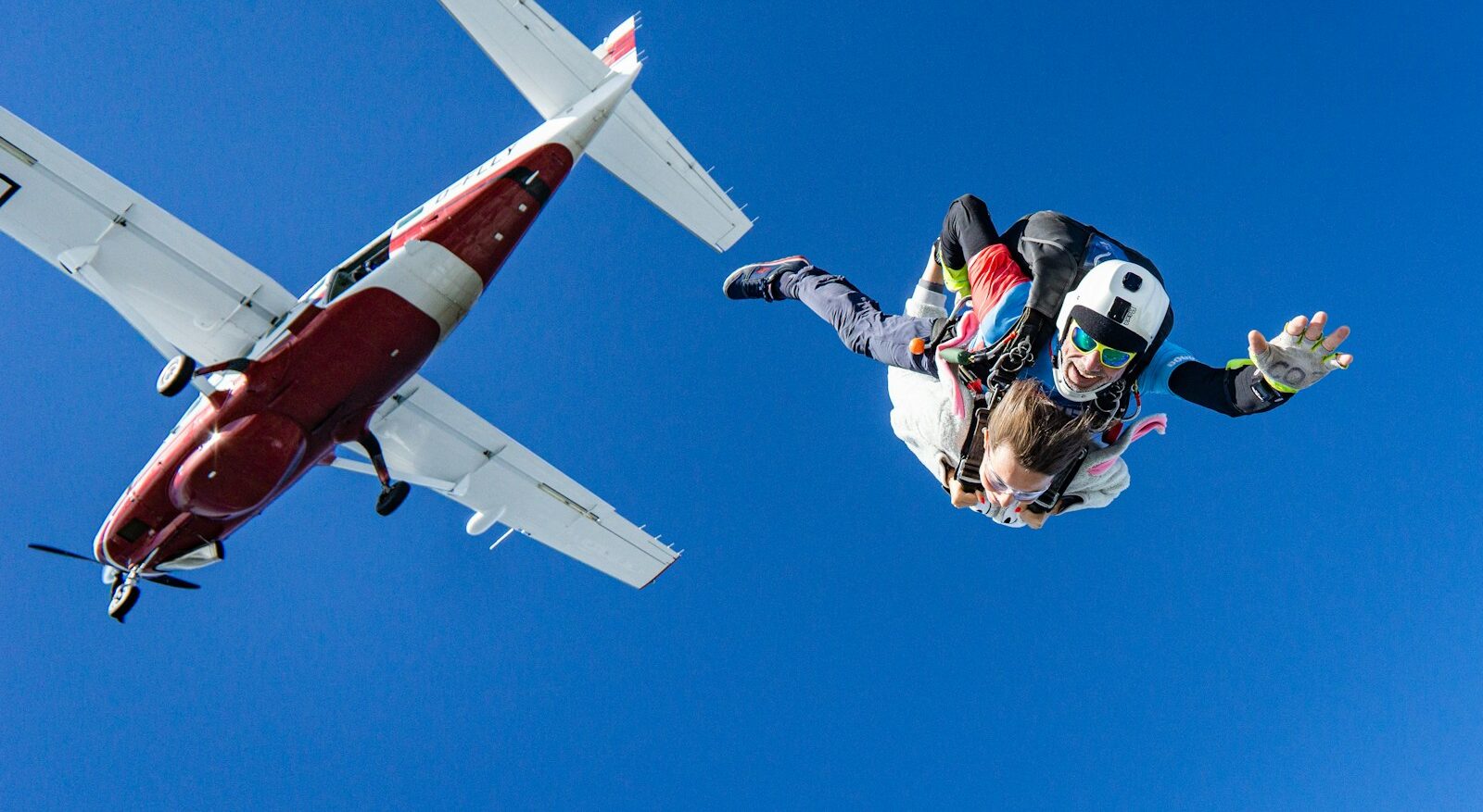 Photo by Kamil Pietrzak white and red airplane in mid air during daytime